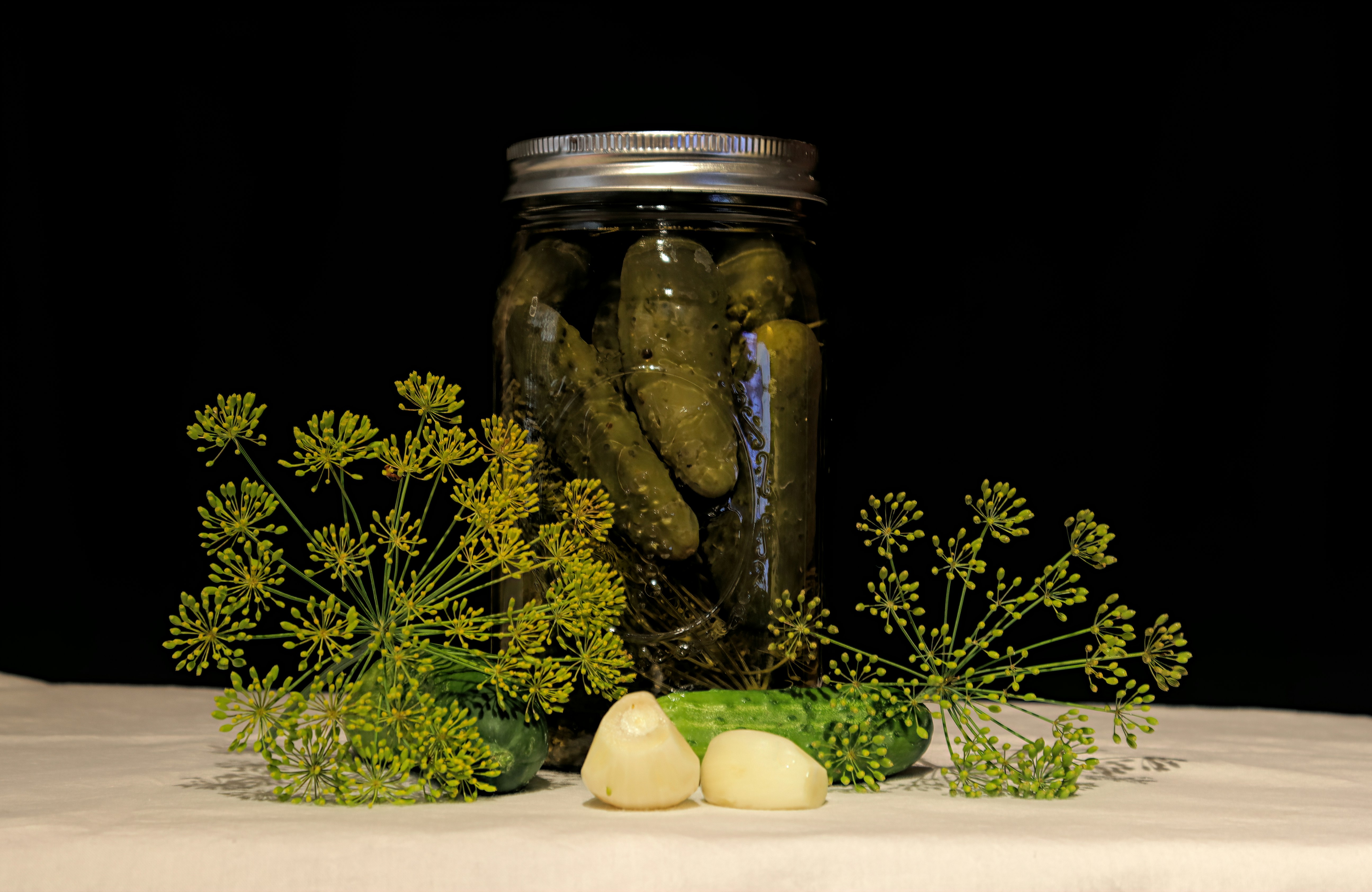 Pale commercial pickle jars with artificial coloring and preservatives on sterile white background